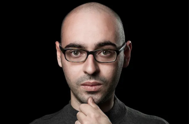 Salvatore Aranzulla il blogger famoso con mano sul mento occhiali e sfondo nero